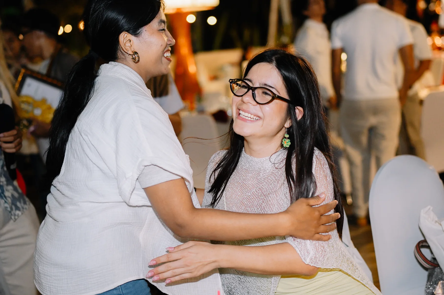 Two students embracing and smiling at the closing dinner in the evening